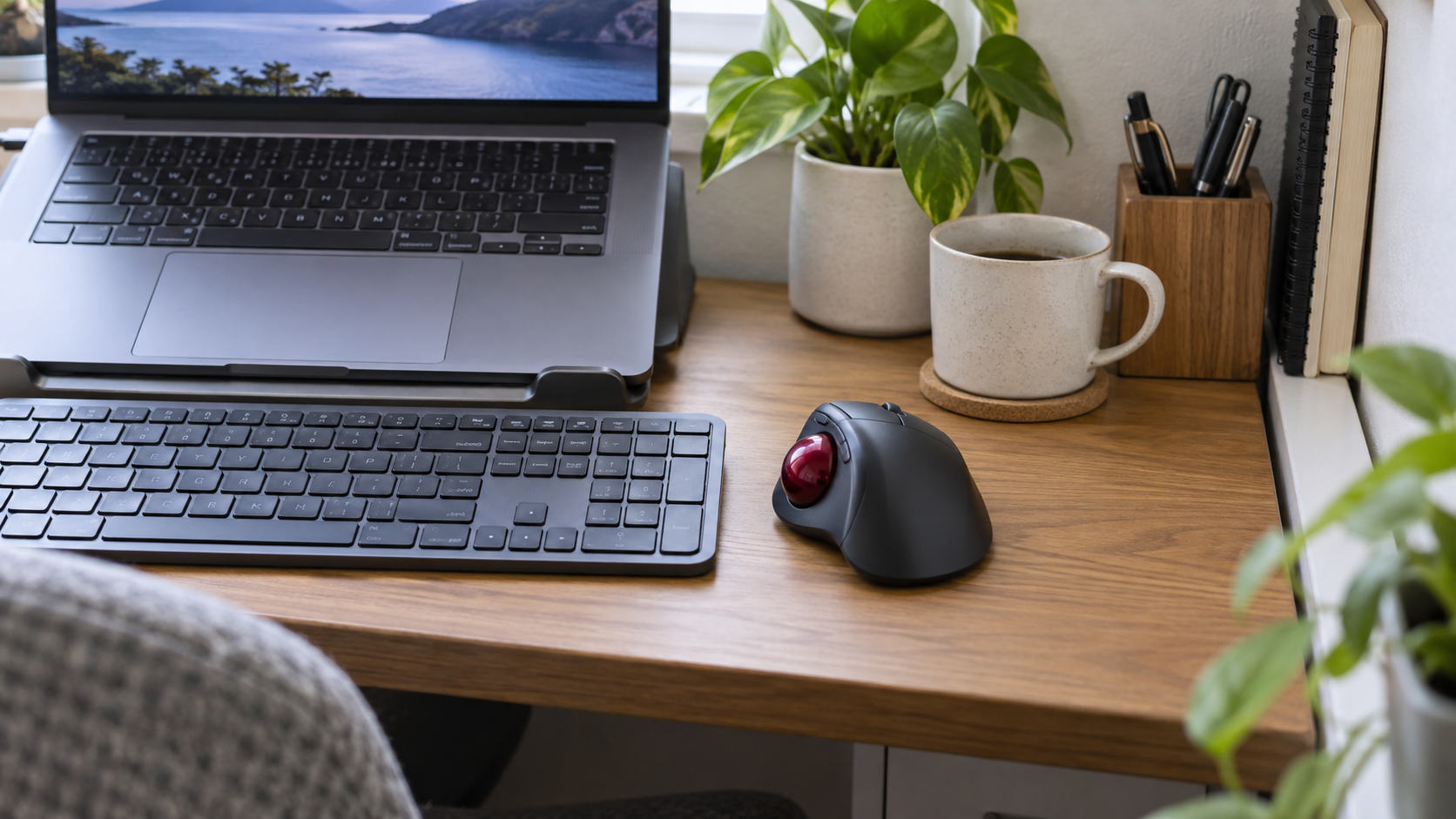 ノートPCとキーボードの横でワイヤレスマウスを使うイメージ